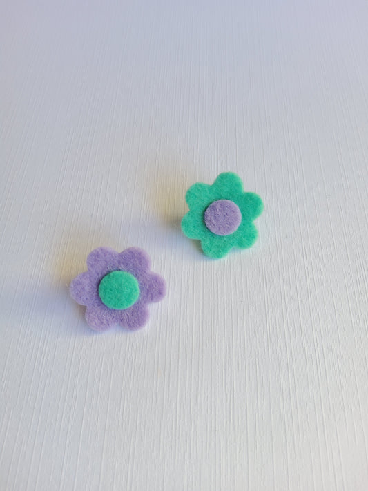 Two felt flower lapel pins on a textured white background