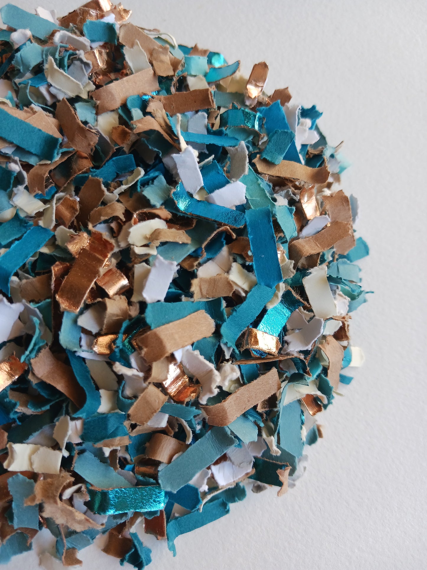 Colorful confetti in blue, brown, and white on a white background