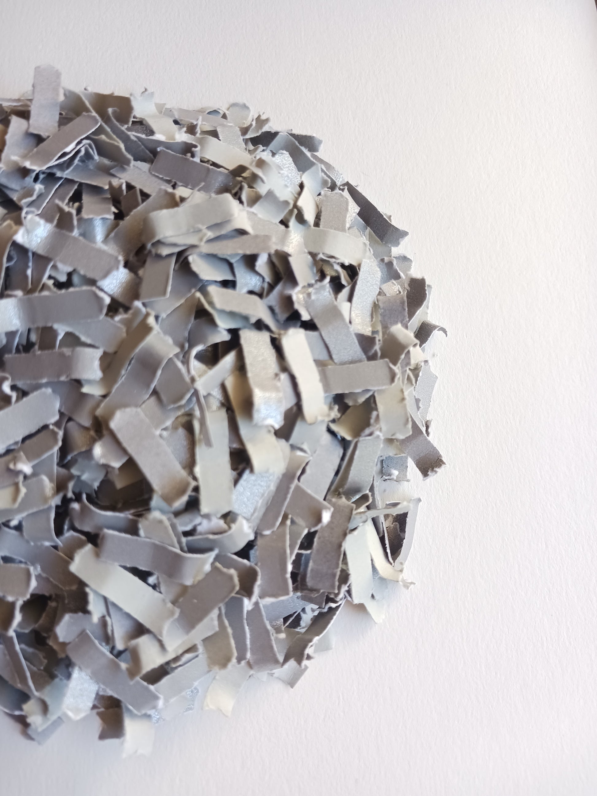 Silver grey confetti close-up shot on white background. 