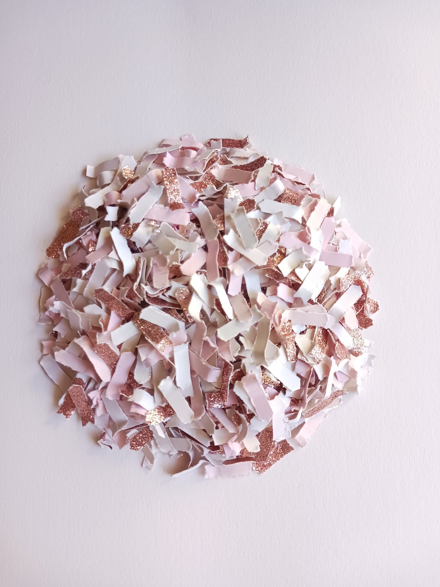 Rose gold, pink and white confetti on a white background