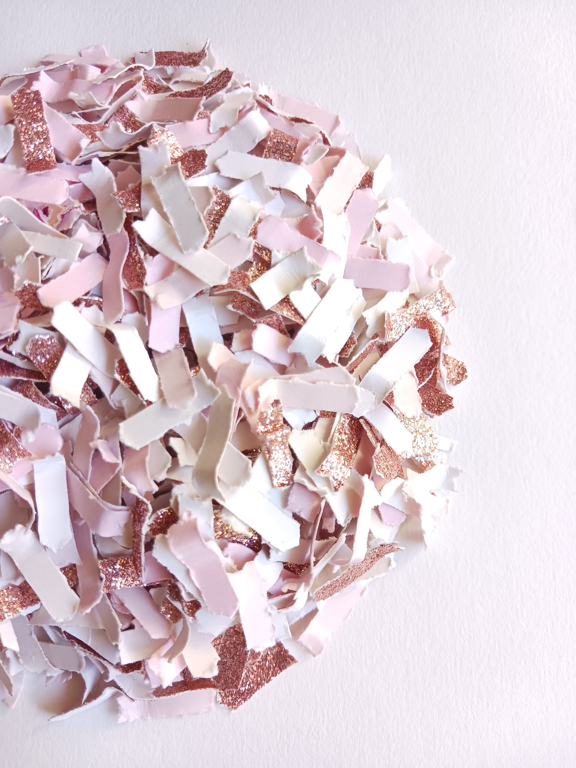 Pink and rose gold confetti on a white background