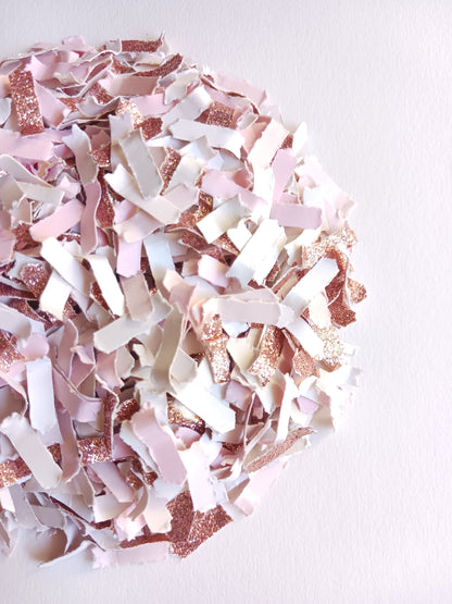 Pink and rose gold confetti on a white background