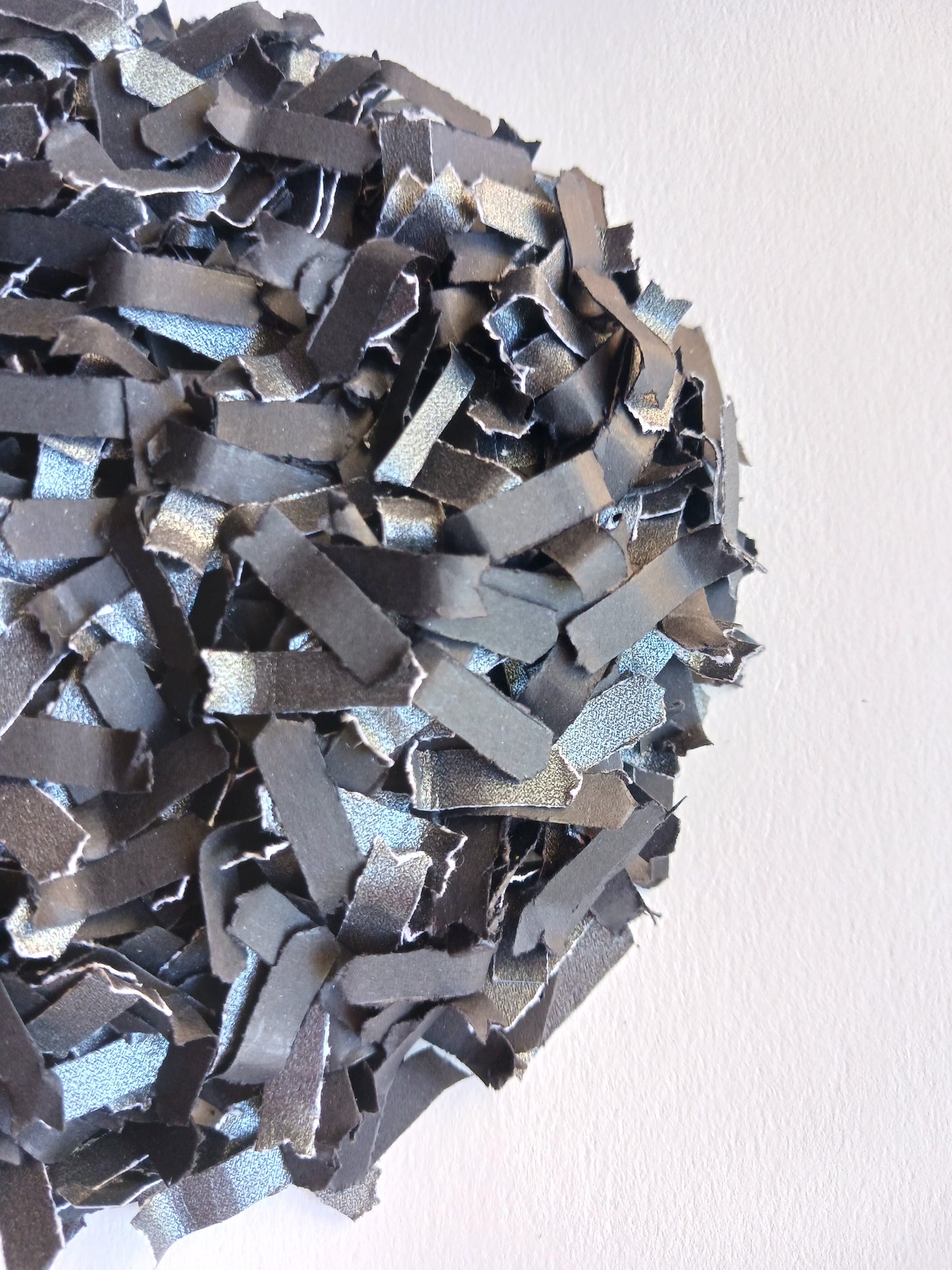 Close-up of black paper confetti on a white background. 