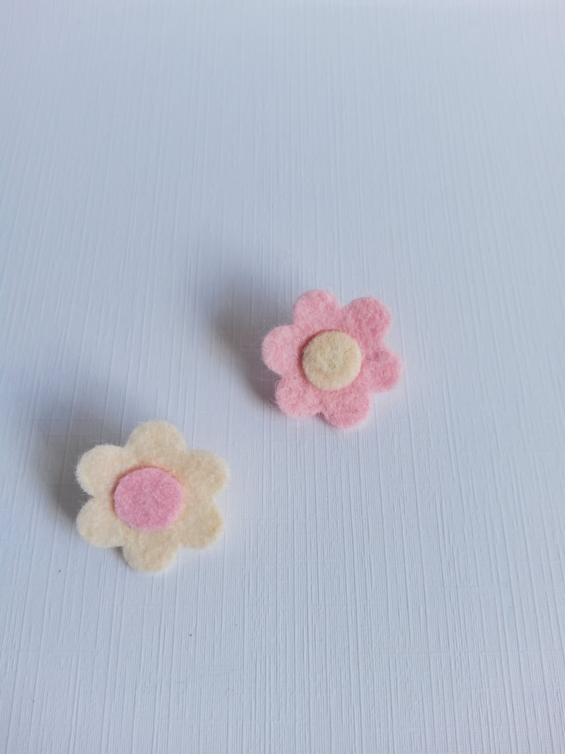 Two felt flower shapes on a white background