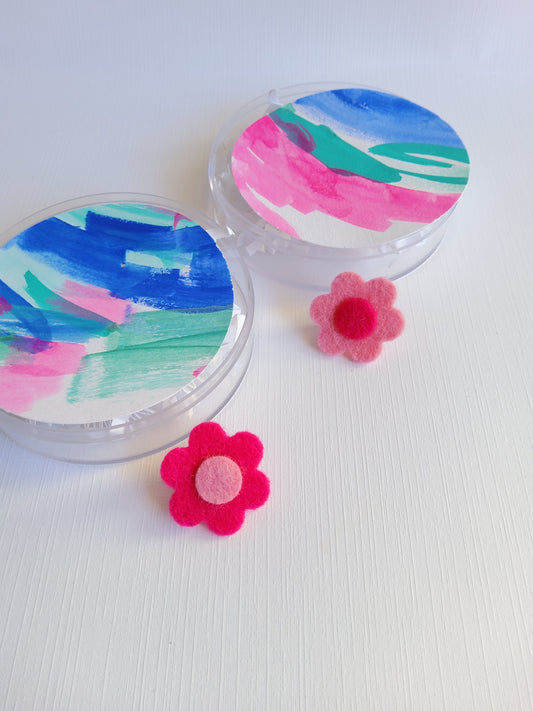 Colorful tag with felt flower pins on a white background