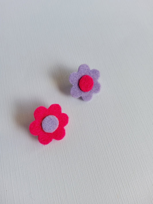 Two felt flower-shaped pins on a light gray background