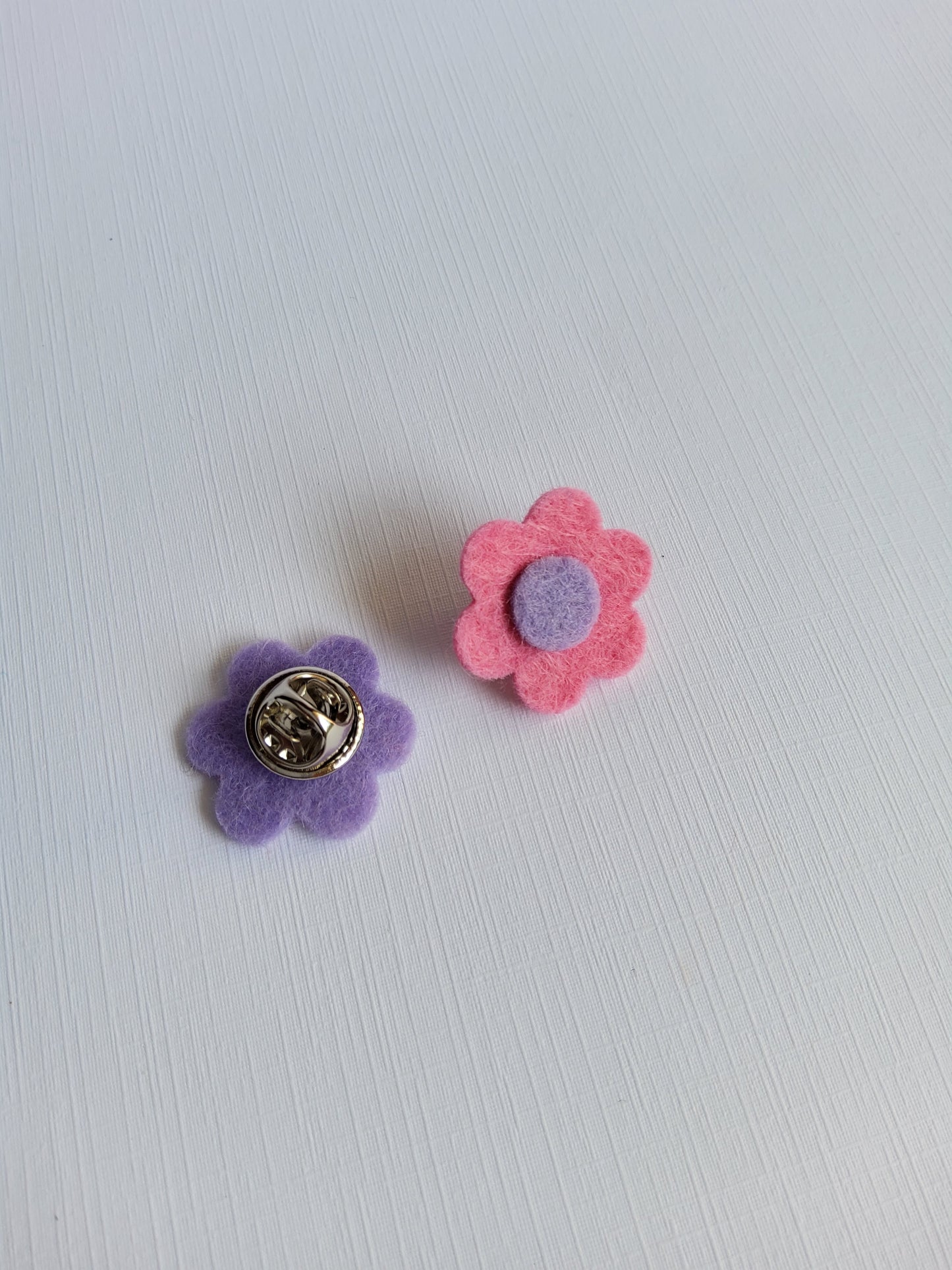 Flower-shaped pins on a light gray background