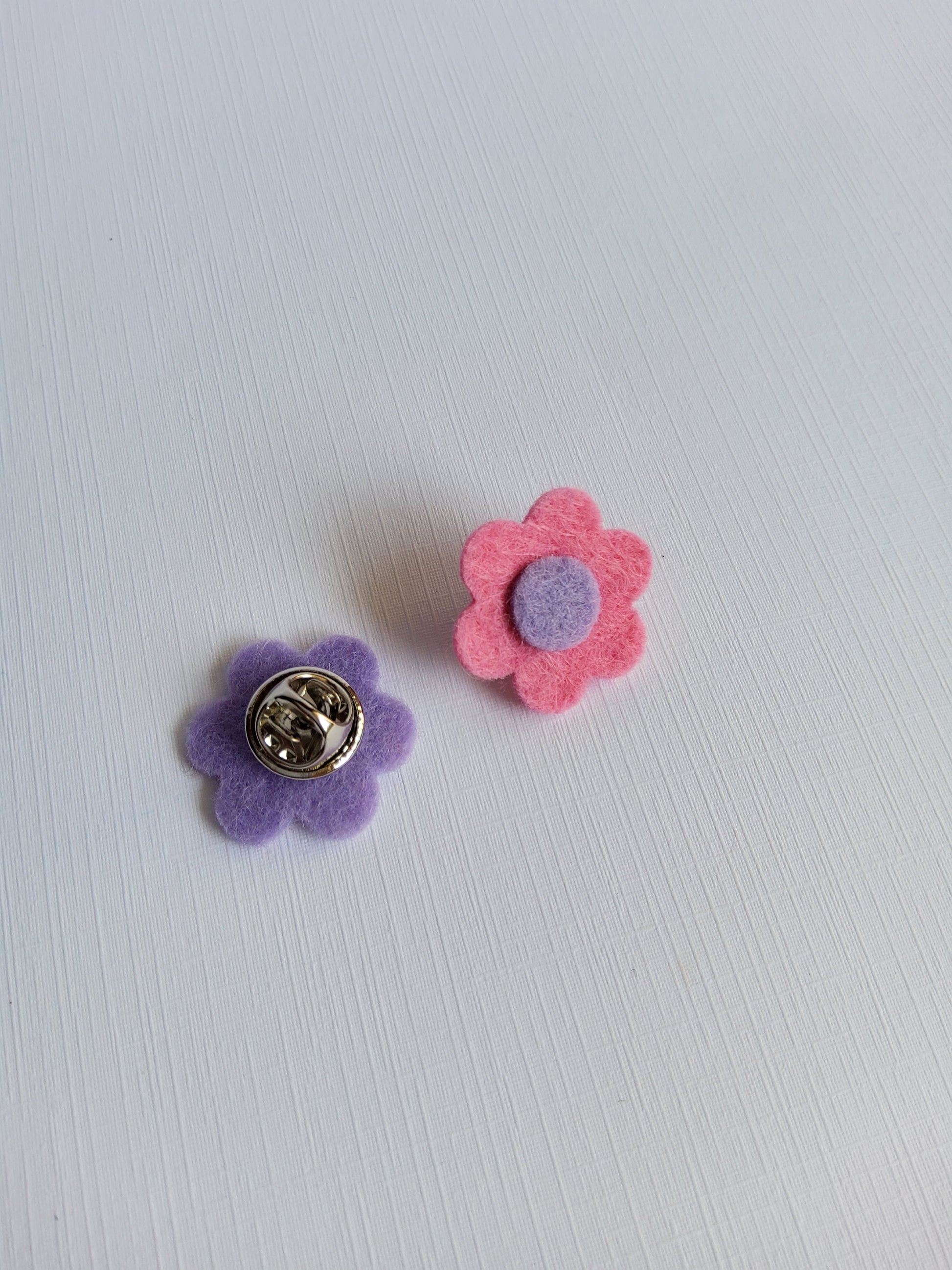 Flower-shaped pins on a light gray background