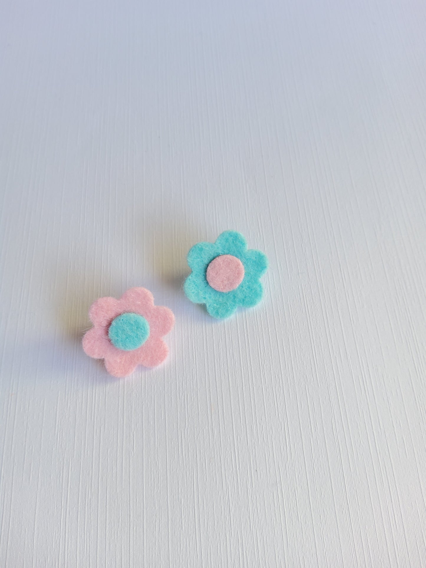 Two felt flower pins on a light gray background