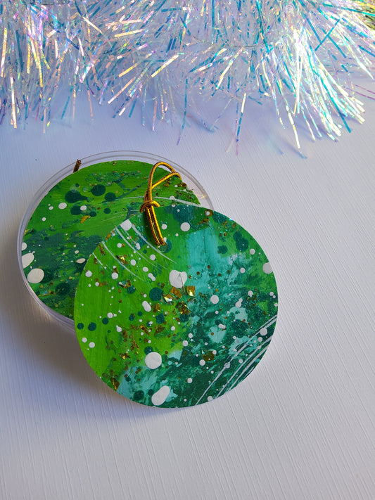 Green and gold glitter abstract hand-painted round gift tags with gold cords and iridescent tinsel background