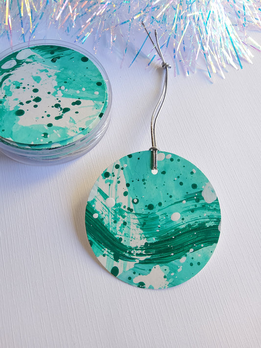 Green abstract hand-painted round gift tags with gold cords and iridescent tinsel background