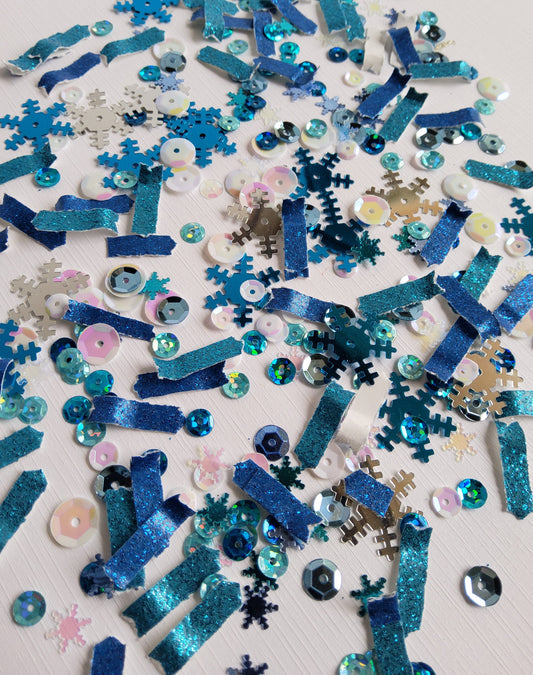 Blue and silver confetti with snowflakes on a light background