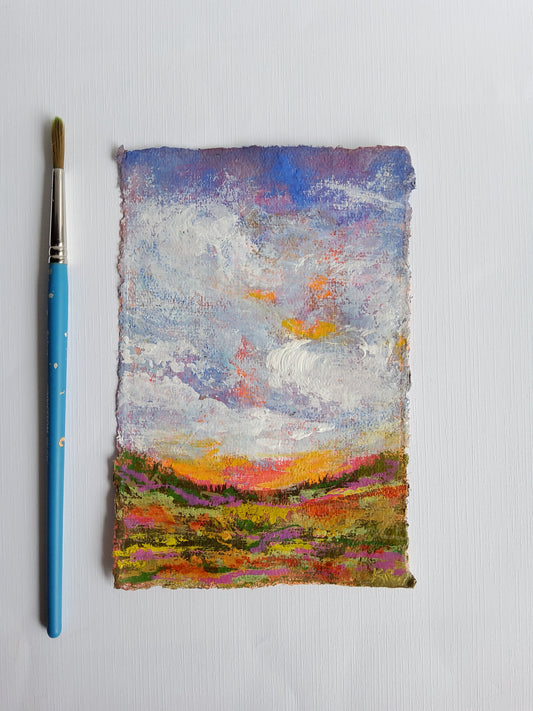 Colorful textured painting on a white background with a paintbrush.