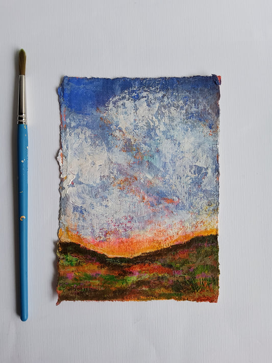 Textured art piece with colorful brush strokes and a blue paintbrush on a light gray background