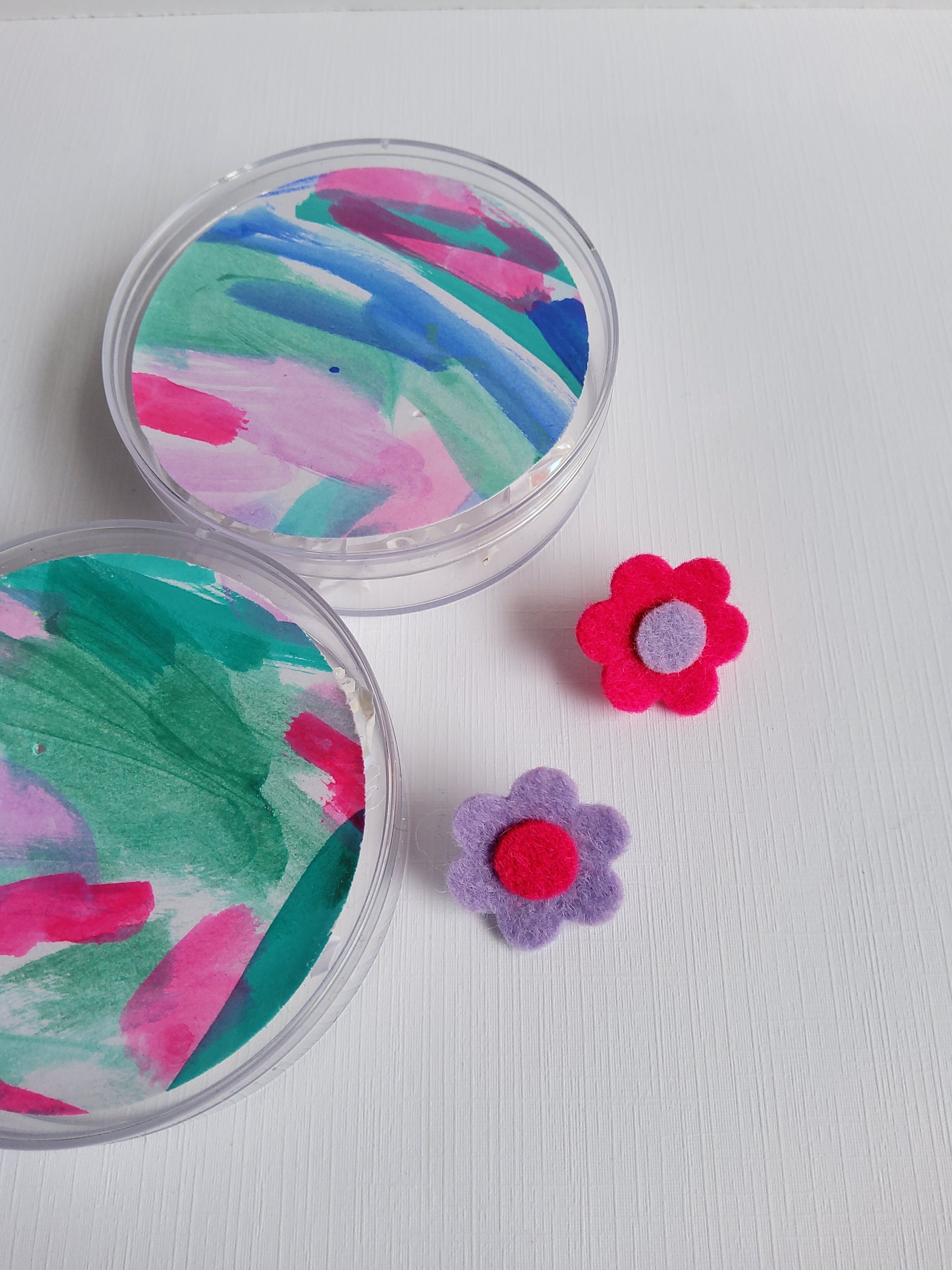 Pink and Lavender flower lapel pins beside colorful tag insert on a light gray background